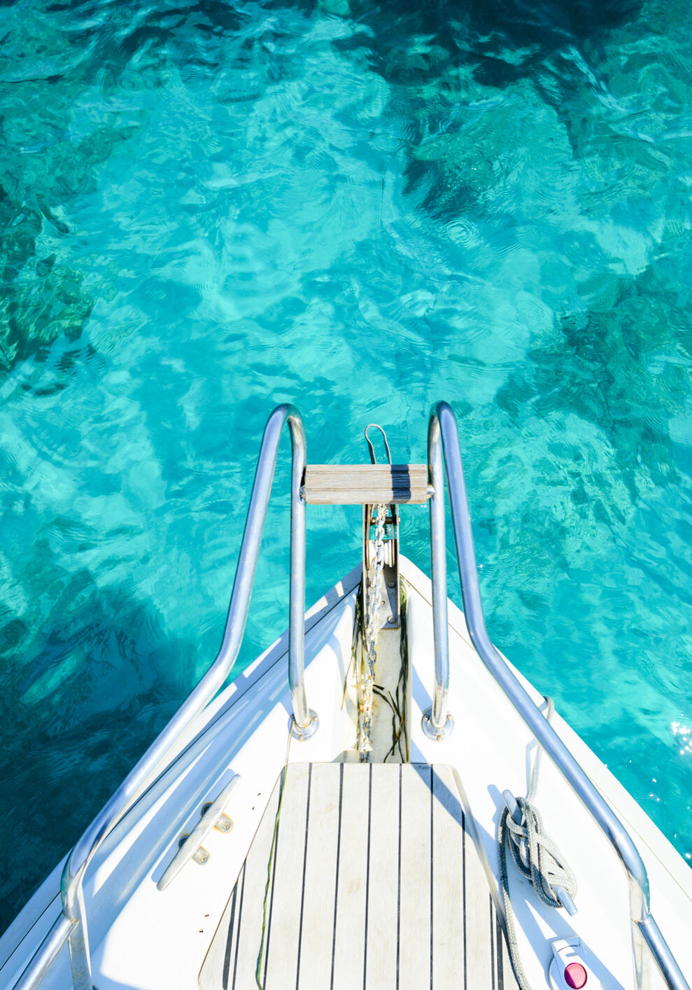 (Selective focus) Stunning view of a bow of a yacht sailing on a beautiful turquoise and transparent sea. Costa Smeralda (Emerald Coast) Sardinia, Italy.